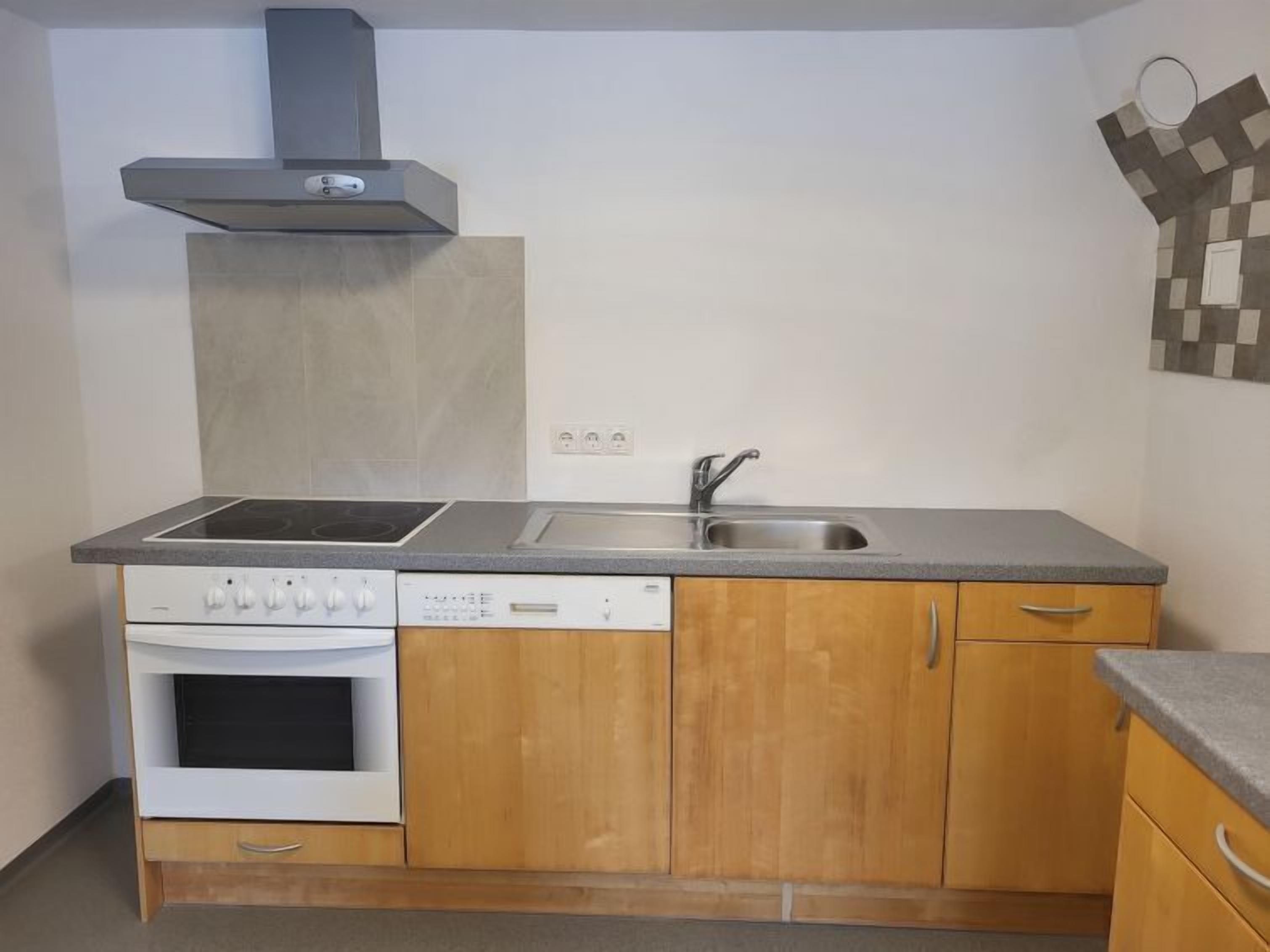 A compact kitchen with a stove, oven, dishwasher, and a sink.