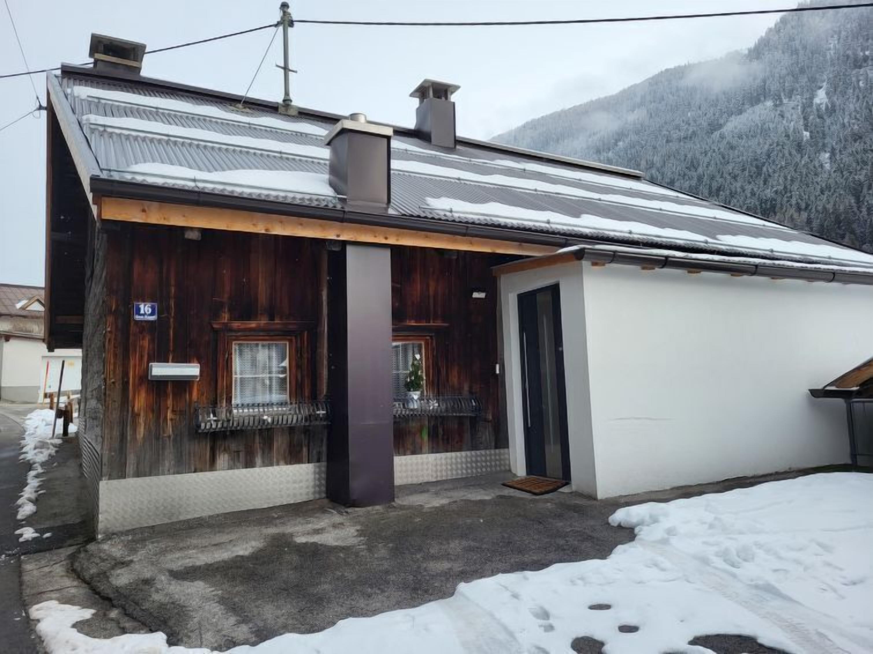 A wooden building with a metal roof, a small porch, and a door.