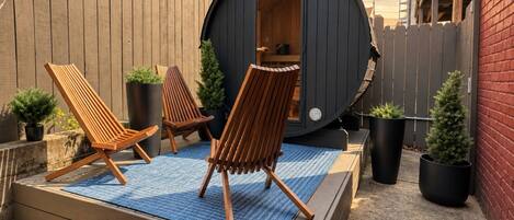 Unwind on slatted loungers beside your own barrel sauna in a fenced courtyard.