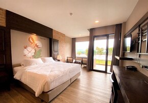 Una habitación de hotel moderna con una cama grande, un escritorio, un televisor y un balcón con vistas.