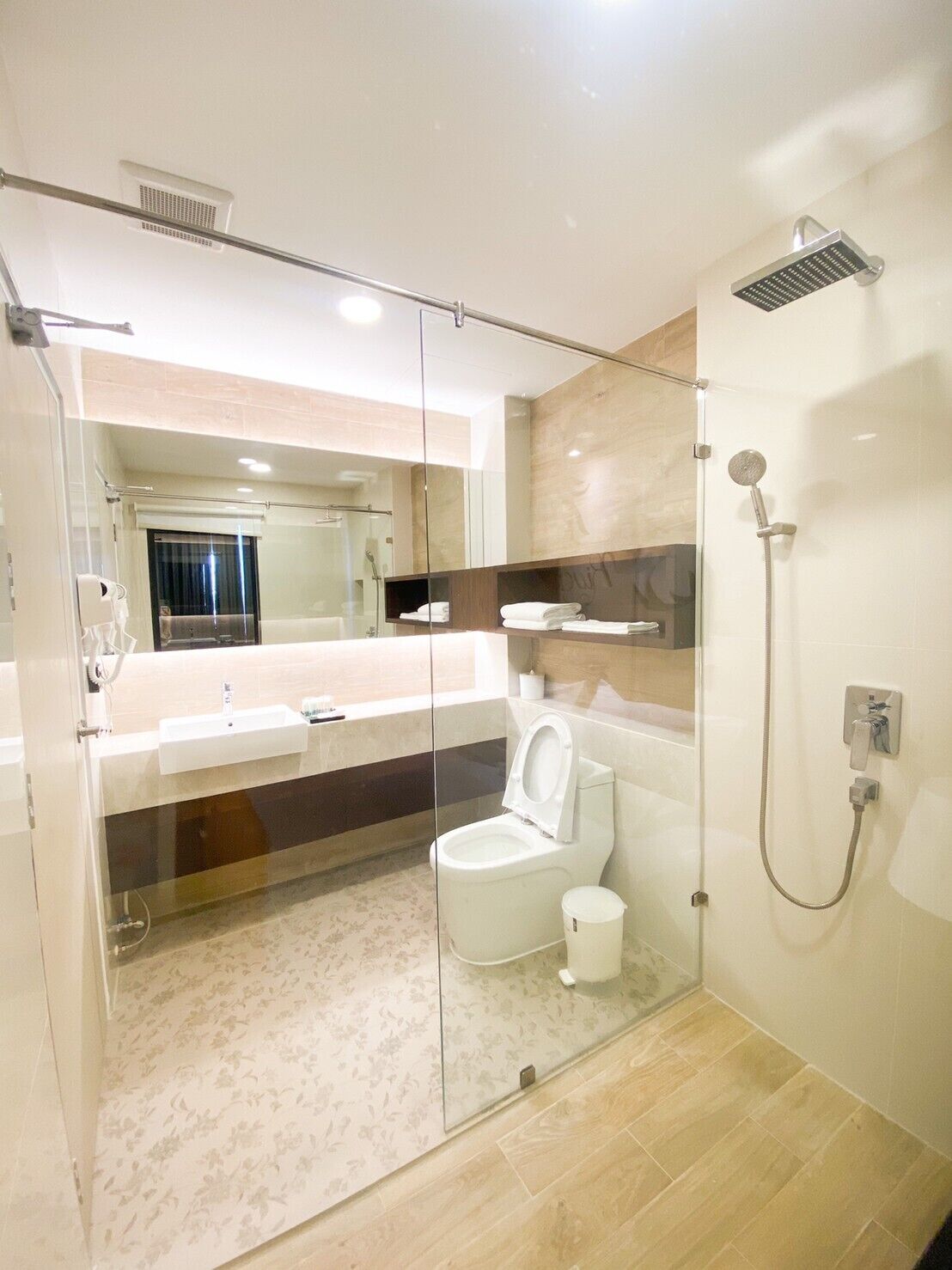A modern bathroom with a glass-enclosed shower, a toilet, and a sink.