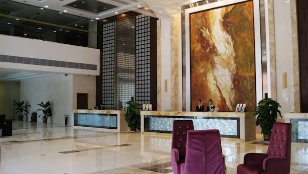 A spacious lobby with a reception desk, seating area, and a large abstract painting on the wall. - Xiangcheng International Hotel (Pingxiang)