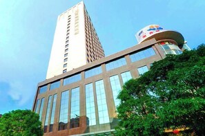 Ein modernes Gebäude mit einem markanten Turm und einer gebogenen Struktur mit Beschilderung.