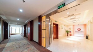 A hotel lobby with a long corridor, a reception desk, and a sign indicating the exit. - Xiangcheng International Hotel (Pingxiang)