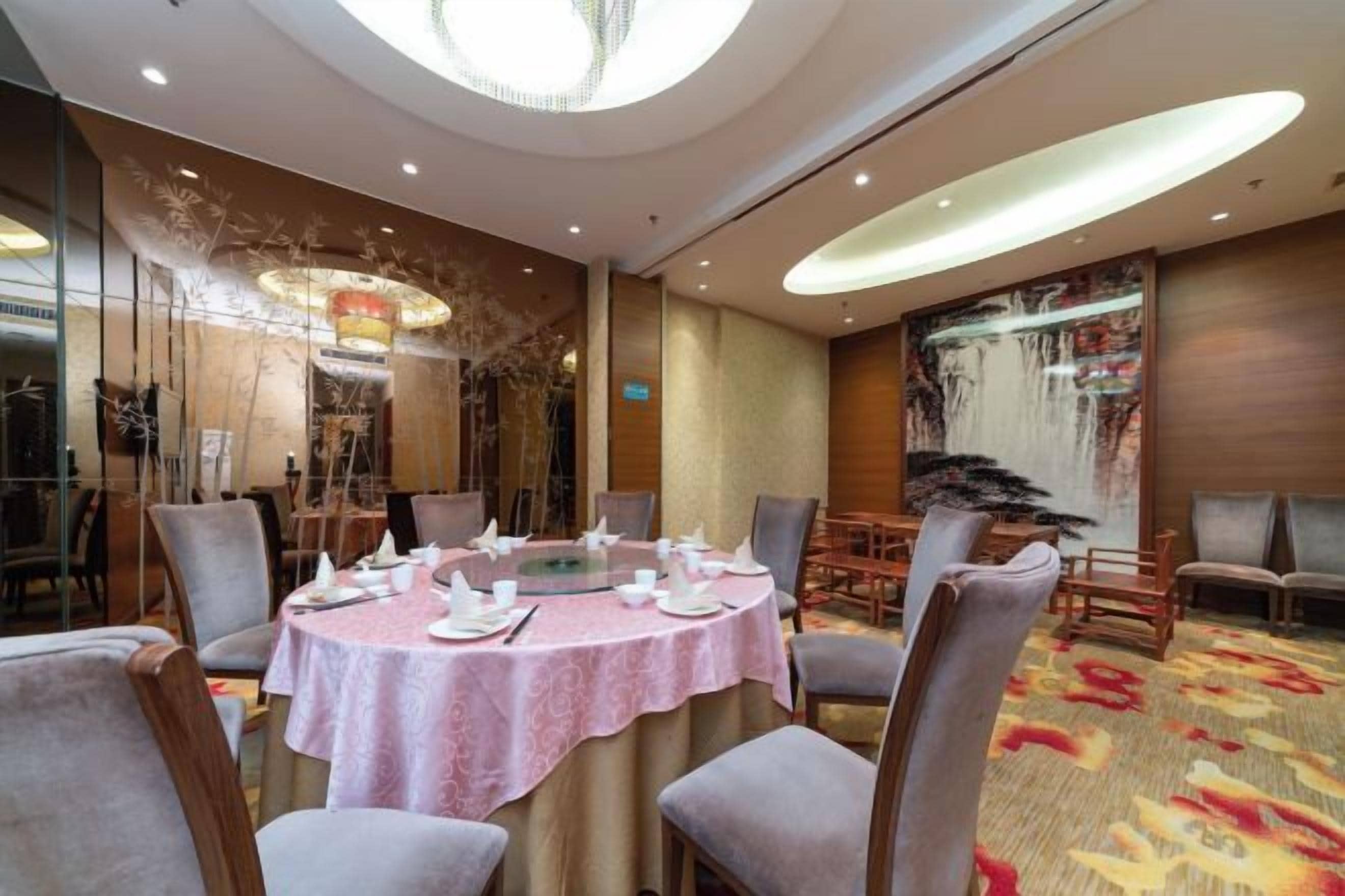 A conference room with a round table, chairs, and a carpeted floor.