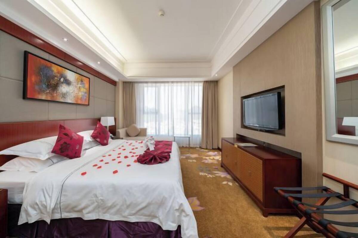 Une chambre d’hôtel équipée d’un lit, d’une télévision, d’un bureau et d’une chaise.