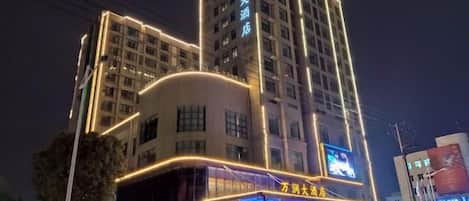 A multi-story hotel with illuminated signage and a prominent entrance.