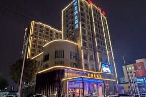 A multi-story hotel with illuminated signage and a prominent entrance. - Wanrun Hotel (Rui'an)