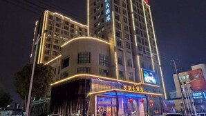 Un hôtel à plusieurs étages, doté d’une enseigne lumineuse et d’un grand écran numérique sur sa façade.
