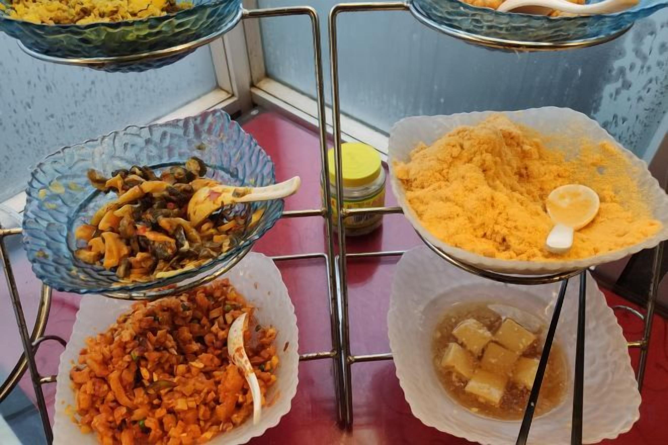 A buffet setup with various dishes in bowls and containers.