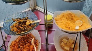 A buffet setup with various dishes in bowls and containers.