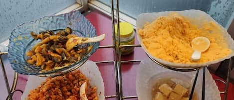 A buffet setup with various dishes in bowls and containers.