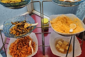 Una mesa de buffet con diferentes platos en cuencos y recipientes.