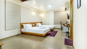 Une chambre d’hôtel avec deux lits, un plafond en bois et un coin cuisine.