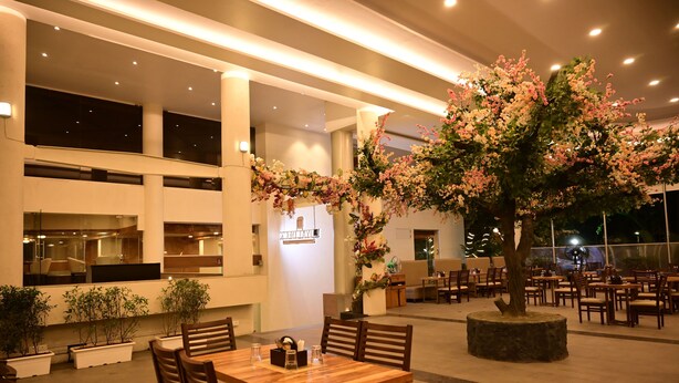 Un restaurant avec des tables à l’intérieur, un grand arbre artificiel et une enseigne sur laquelle on peut lire « YOKOHAMA ».