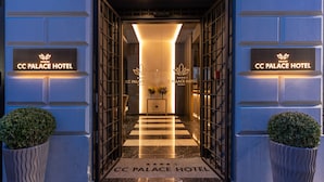 The entrance of CC Palace Hotel with a marble floor and two potted plants. - CC Palace Hotel Roma (Rome)