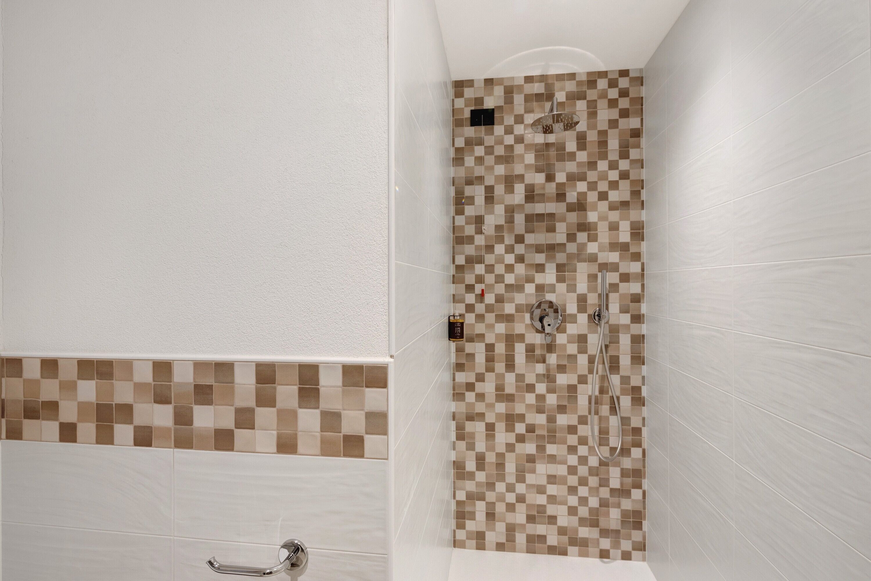 Een badkamer met een douchewand met ruitpatroon, een witte badkuip en een wit toilet.