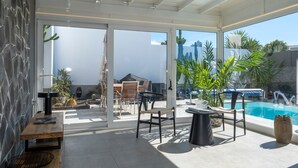 A modern outdoor patio with a pool, stone wall, and furniture. - Vacation Villa 'Casa Saidera ' with Private Pool, Wi-Fi and Air Conditioning (Playa Blanca)