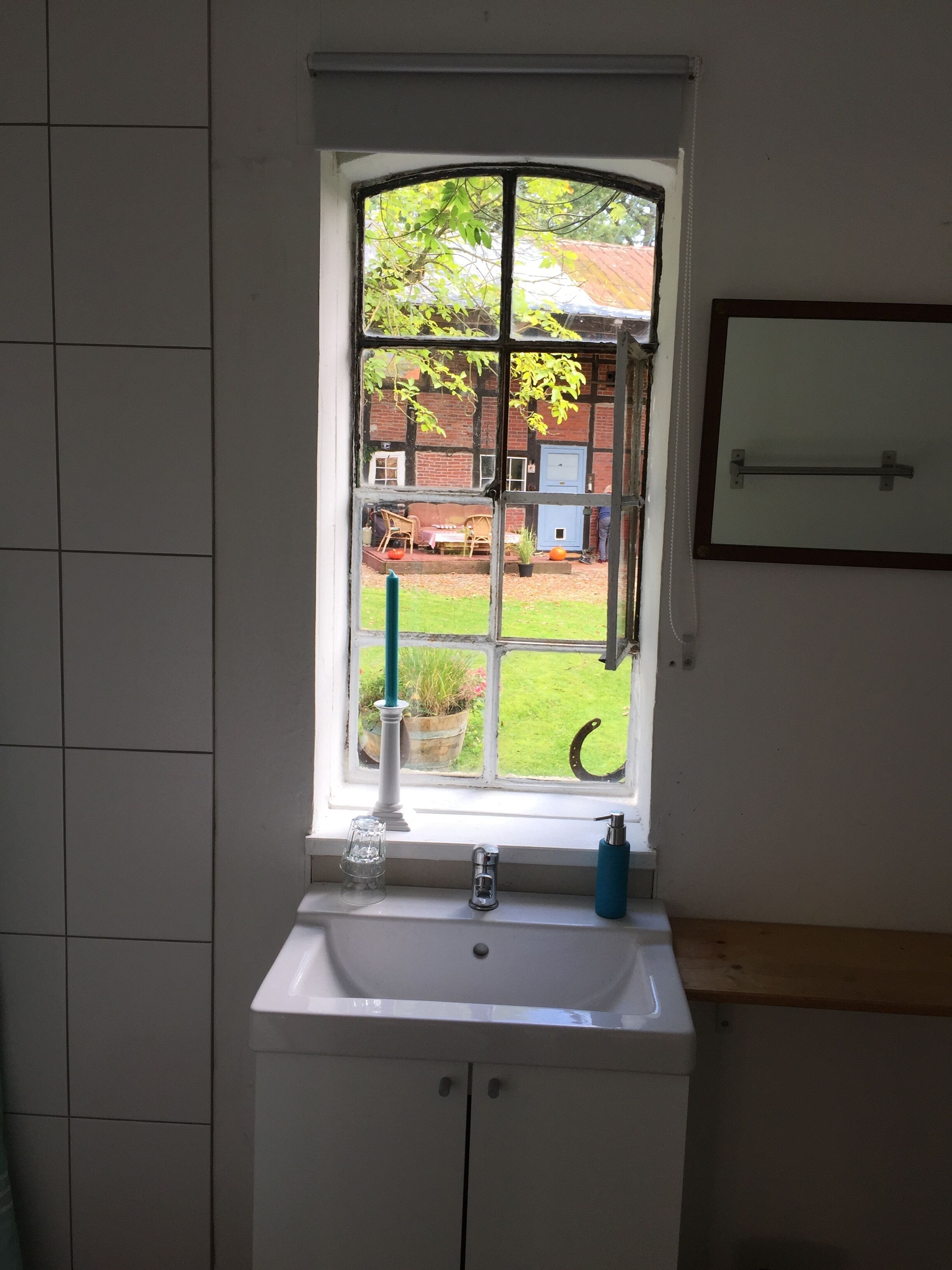 A bathroom with a window, sink, and a towel rack.