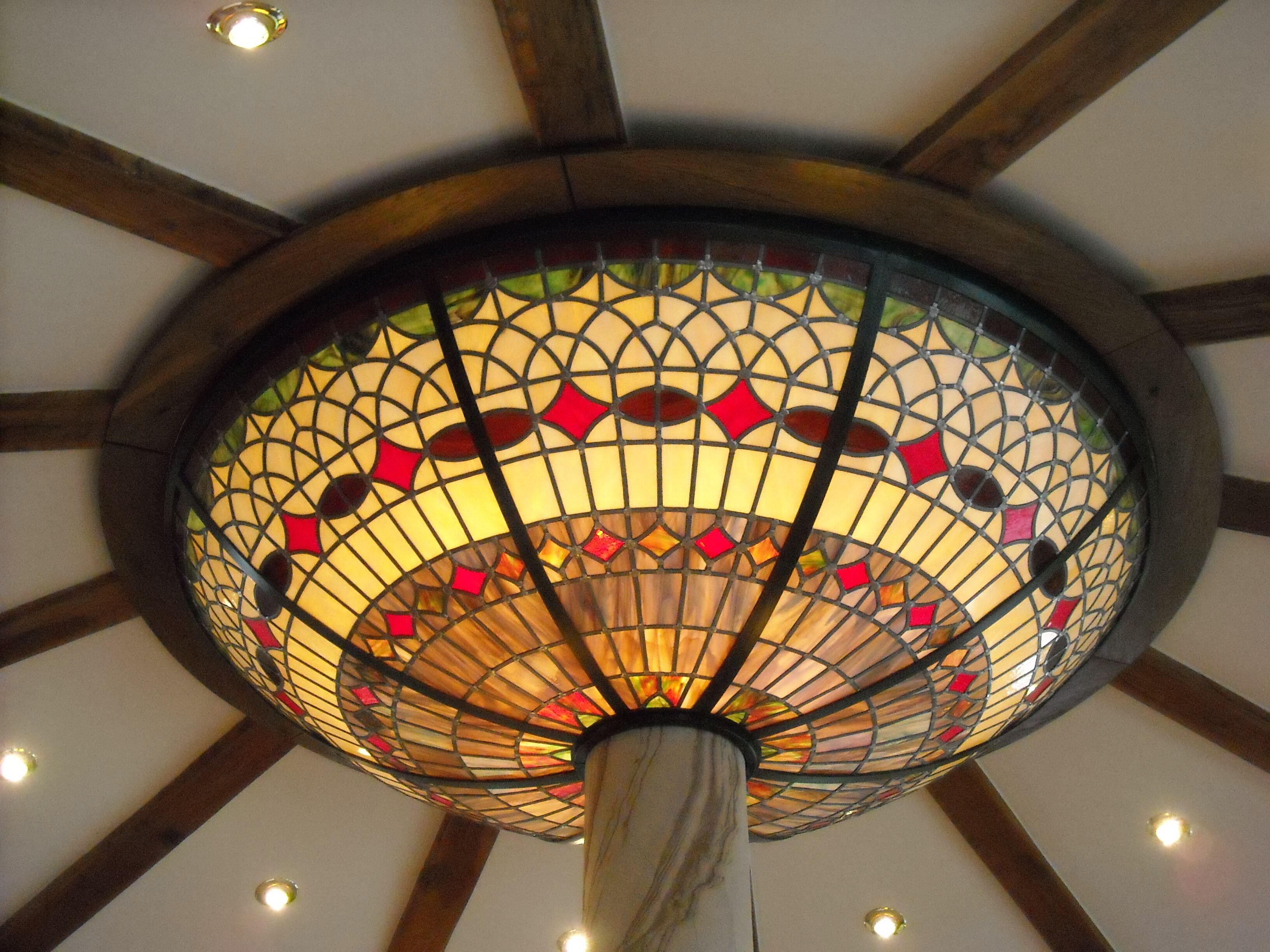 A ceiling with a stained glass lamp.