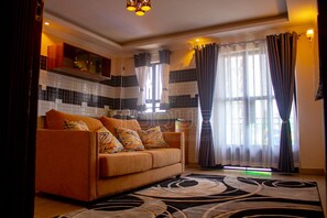 Habitación ejecutiva, 1 cama Queen size | Área de sala de estar | Smart TV de 55 pulgadas con canales digitales y televisión