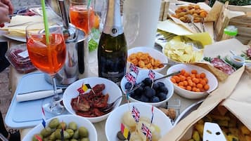 A table with various food items, drinks, and a bottle of wine.