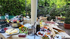 An outdoor buffet table with various food items, drinks, and utensils. - Hotel Arcobaleno Siena (Siena)