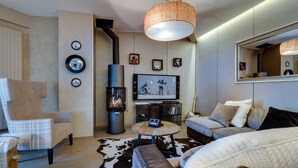 Una sala de estar moderna con chimenea, un espejo grande y un televisor.