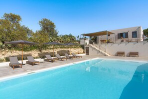 A pool area with lounge chairs and umbrellas, a staircase leading to a building, and a clear sky. - Nice villa with pool near Noto, Sicily (Noto)