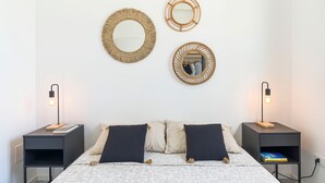 A neatly arranged bedroom with a bed, two nightstands, and three wall mirrors. - Nice villa with pool near Noto, Sicily (Noto)