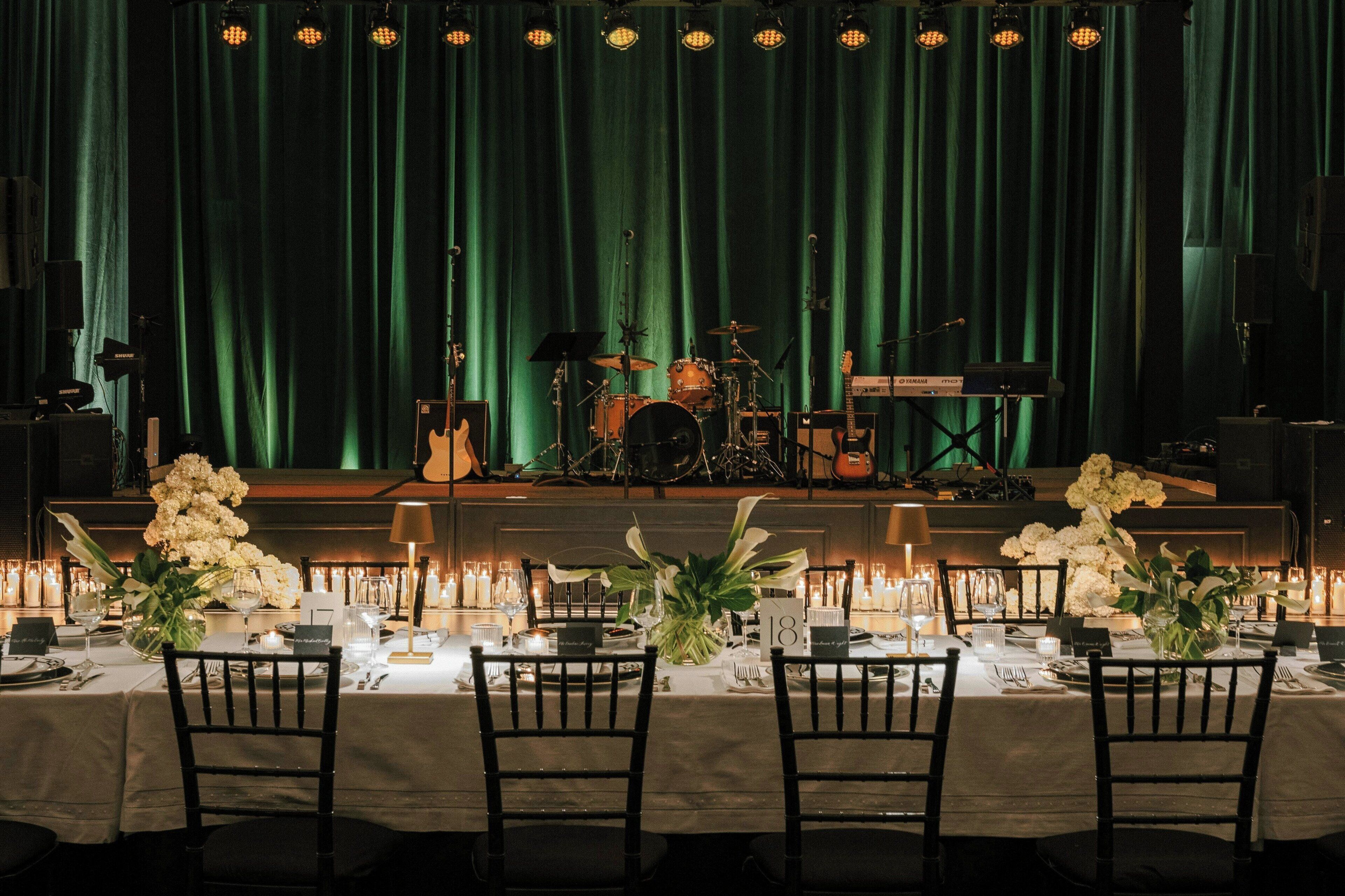 A stage with musical instruments and a green curtain backdrop.