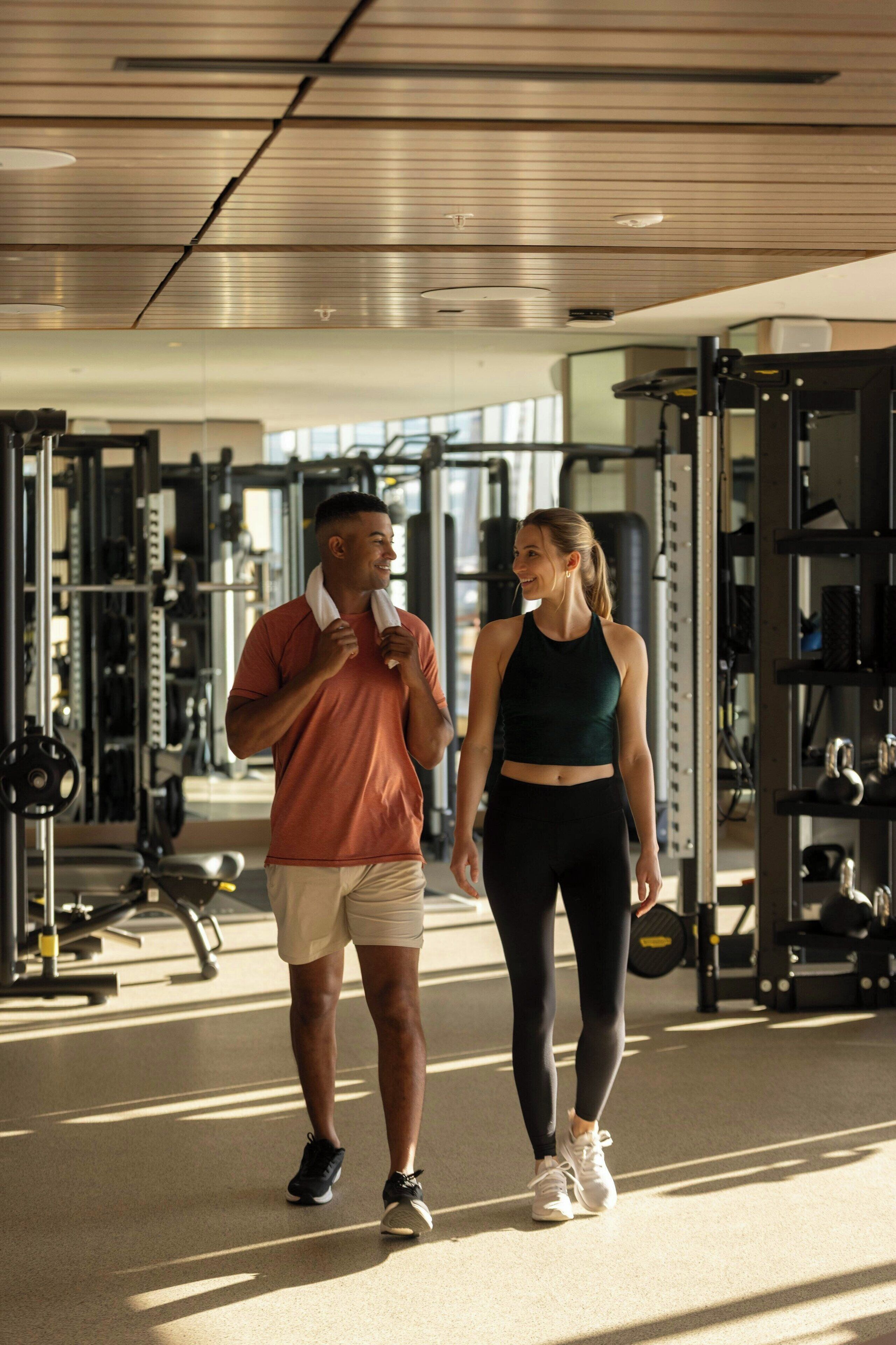 Une salle de sport équipée de matériel d’exercice et une personne qui marche.