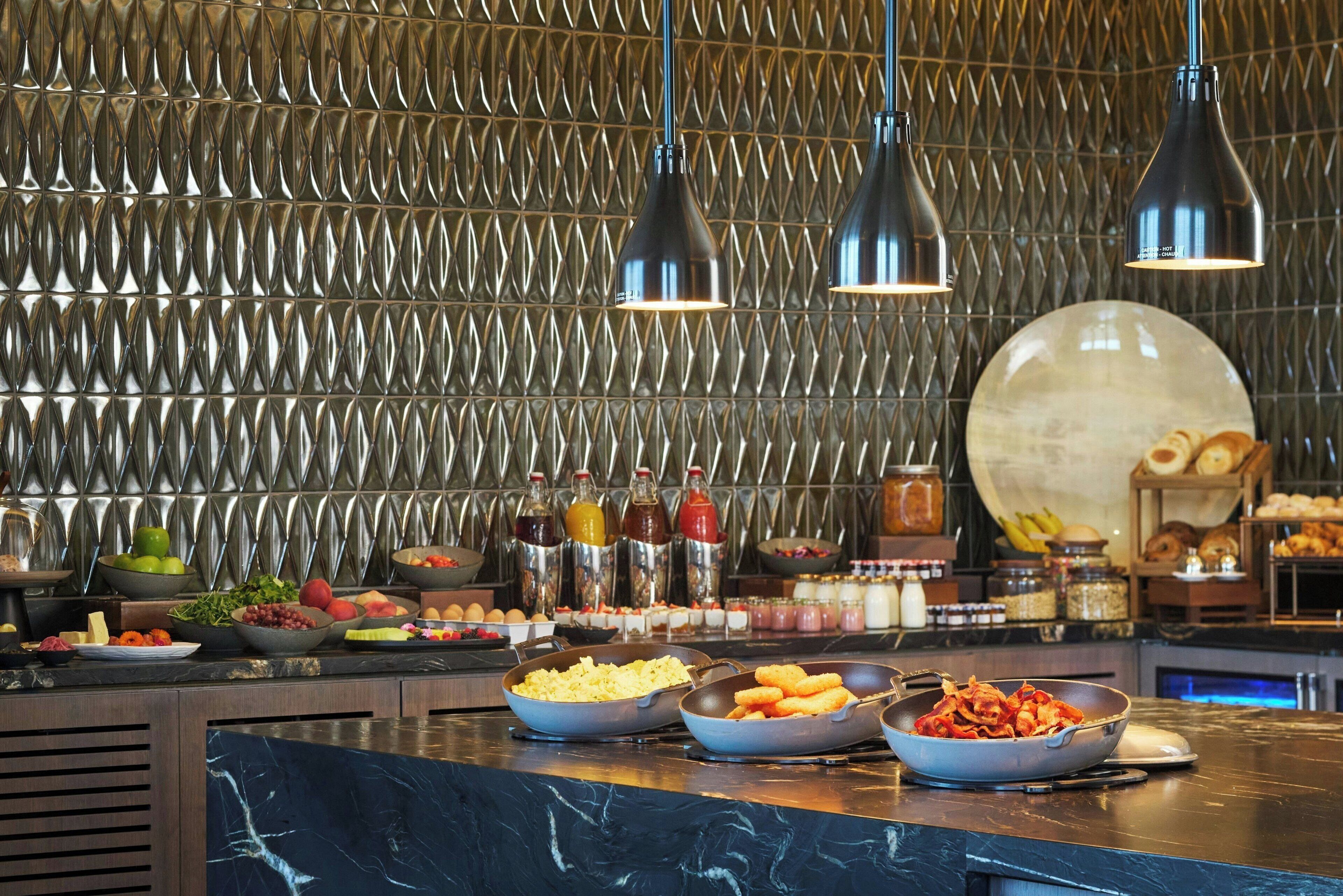 A buffet setup with various food items and condiments.