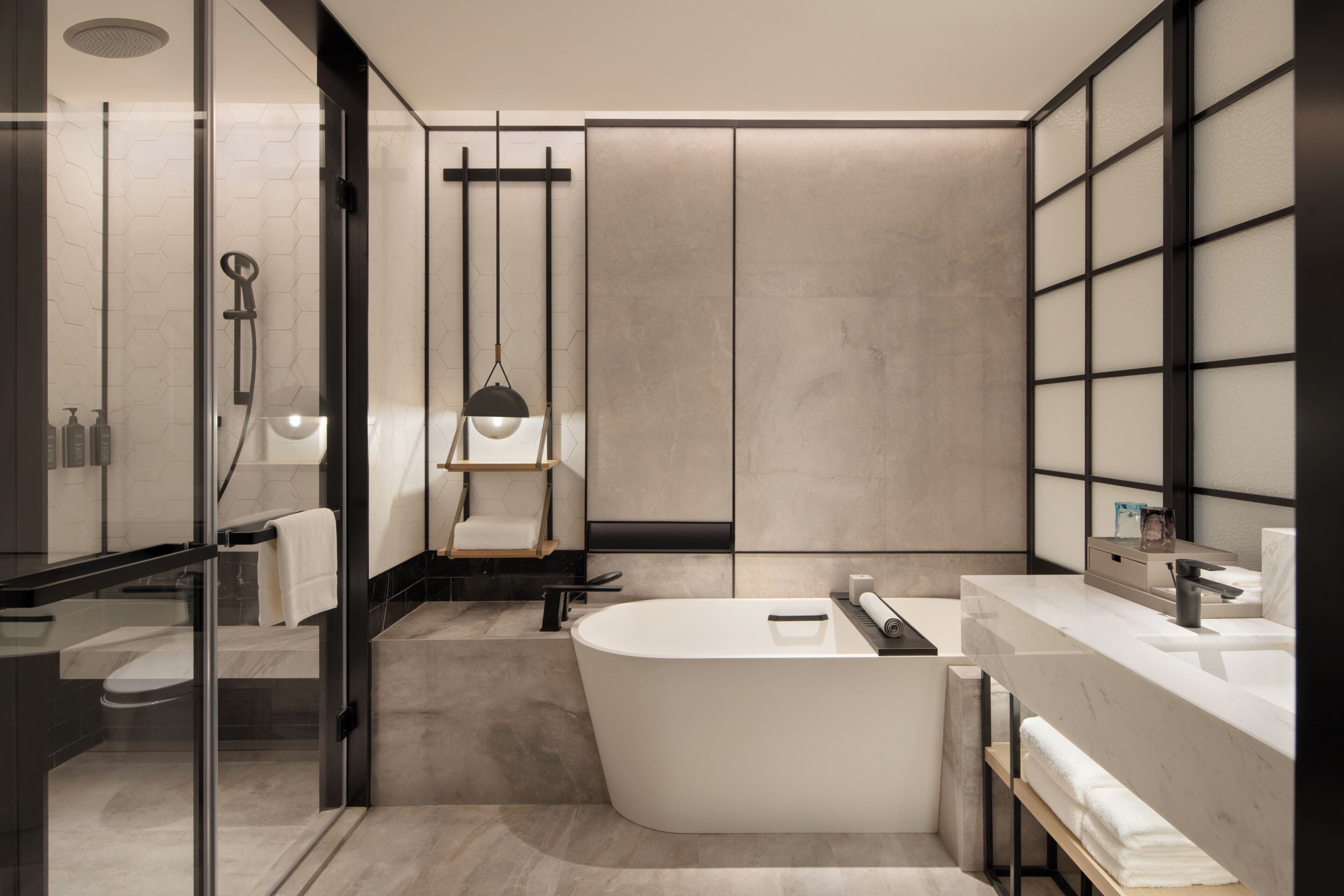 A modern bathroom with a freestanding bathtub, a glass shower enclosure, and a vanity with a mirror.