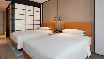 Quarto de hotel moderno com duas camas, uma janela grande e parede com textura.