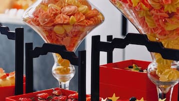 A variety of food items displayed in clear containers and red boxes, including pastries and desserts.