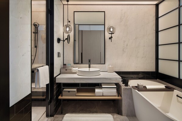 A modern bathroom with a round sink, a large mirror, a bathtub, and a shower area. - Sheraton Xi'An Chanba (Xi'an)