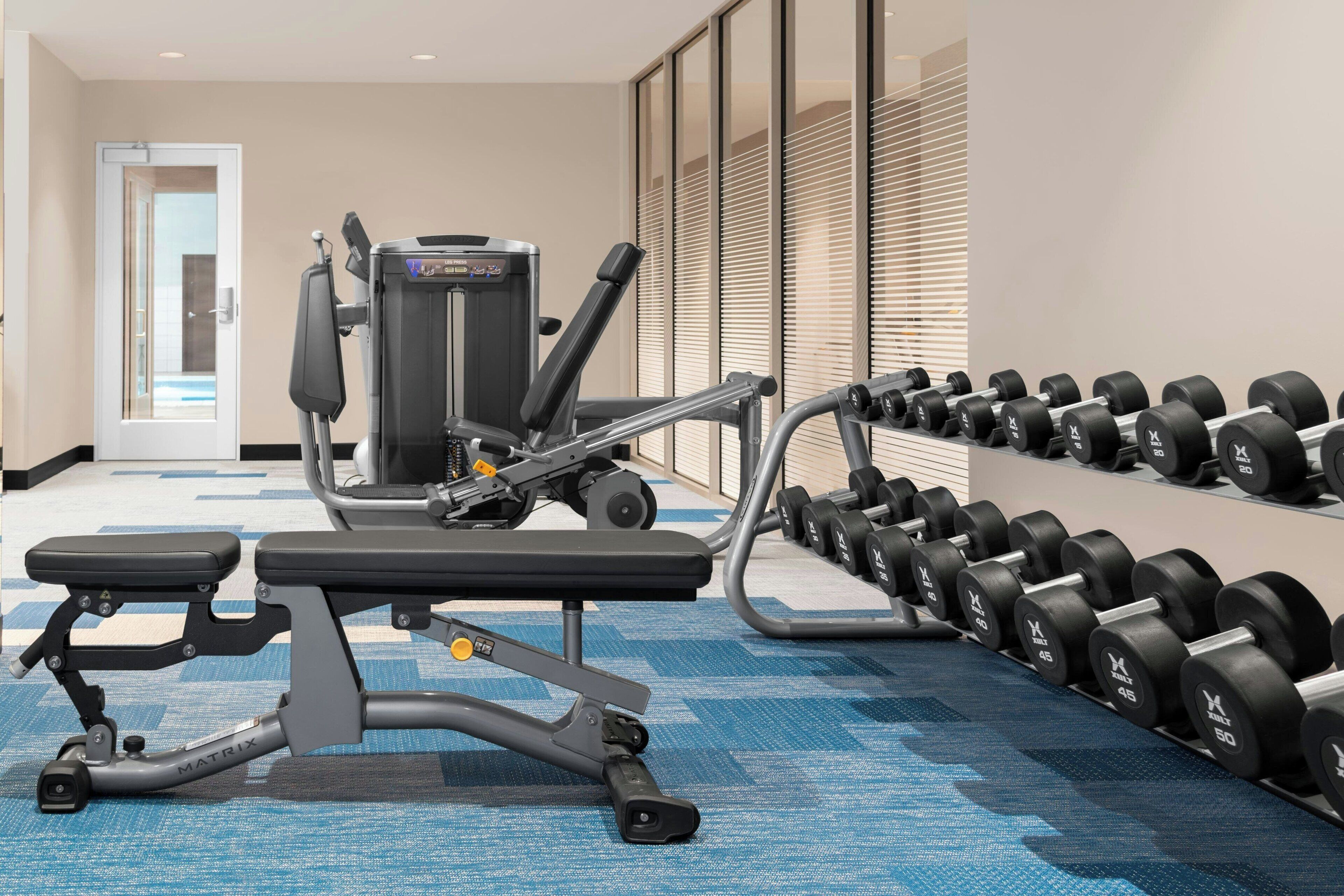 A gym with exercise equipment, including a bench and dumbbells.