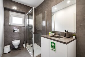 Une salle de bain moderne avec une douche à parois de verre, des toilettes et un lavabo avec un miroir au-dessus.
