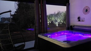A room with a hot tub, a chair, and a view of trees outside. - Hacienda Matea- pool, olive grove, fully fenced, children's playground, barbecue (Pula)
