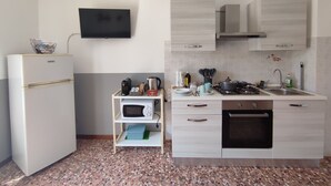 A compact kitchen with a refrigerator, microwave, stove, sink, and cabinets. - Michelangelo - spacious apartment with view in La Morra  (Piemonte)