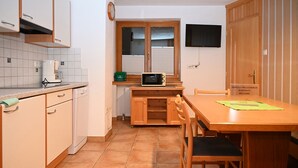 A compact kitchen with a microwave, a coffee maker, and a small window.