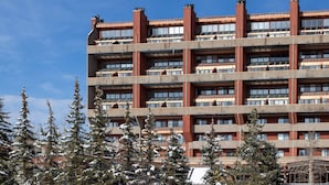 Un edificio de varios pisos con fachada simétrica, que presenta un corredor central y varios balcones.