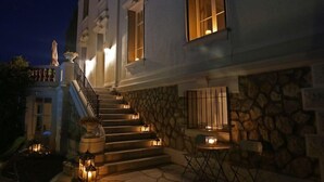 A building with a stone facade, a staircase leading to the entrance, and outdoor seating with tables and chairs. - Stunning Belle Epoque Villa in the heart of Cannes, private pool, secure parking (Cannes)