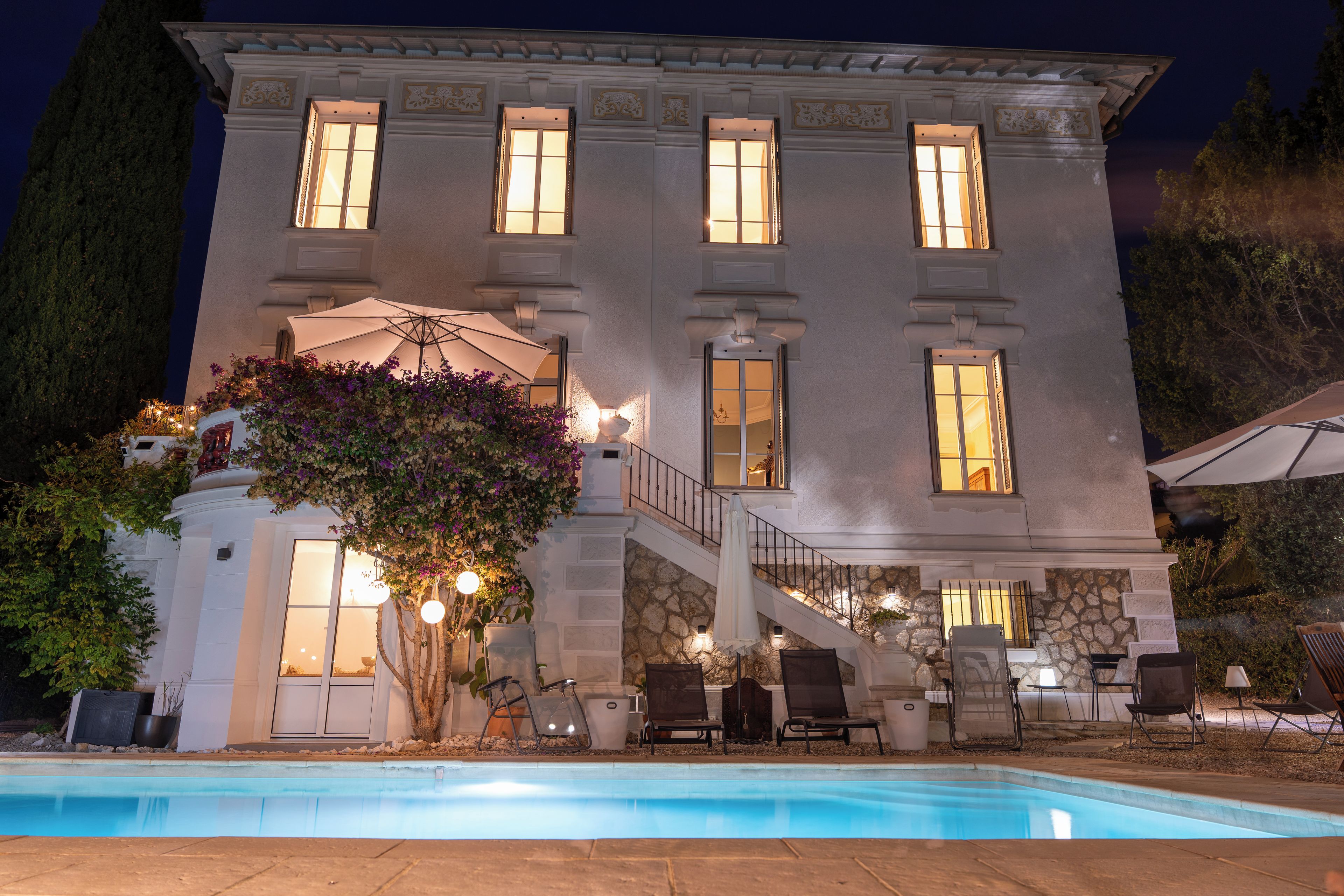 Un grand immeuble à plusieurs étages, avec une piscine en premier plan.