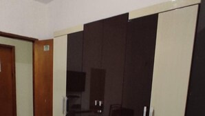 Ein Hotelzimmer mit einem Bett, einem Kleiderschrank und einem Fernseher.