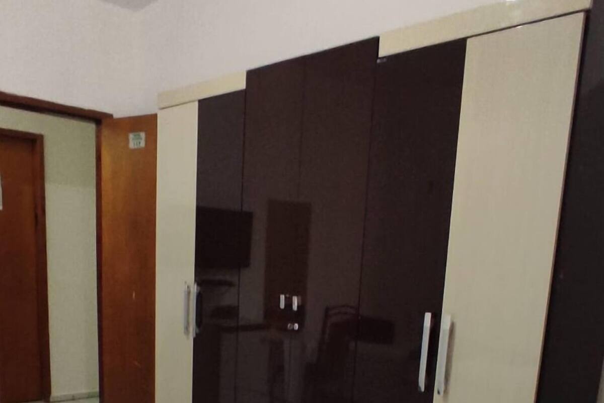Ein Hotelzimmer mit einem Bett, einem Kleiderschrank und einem Fernseher.