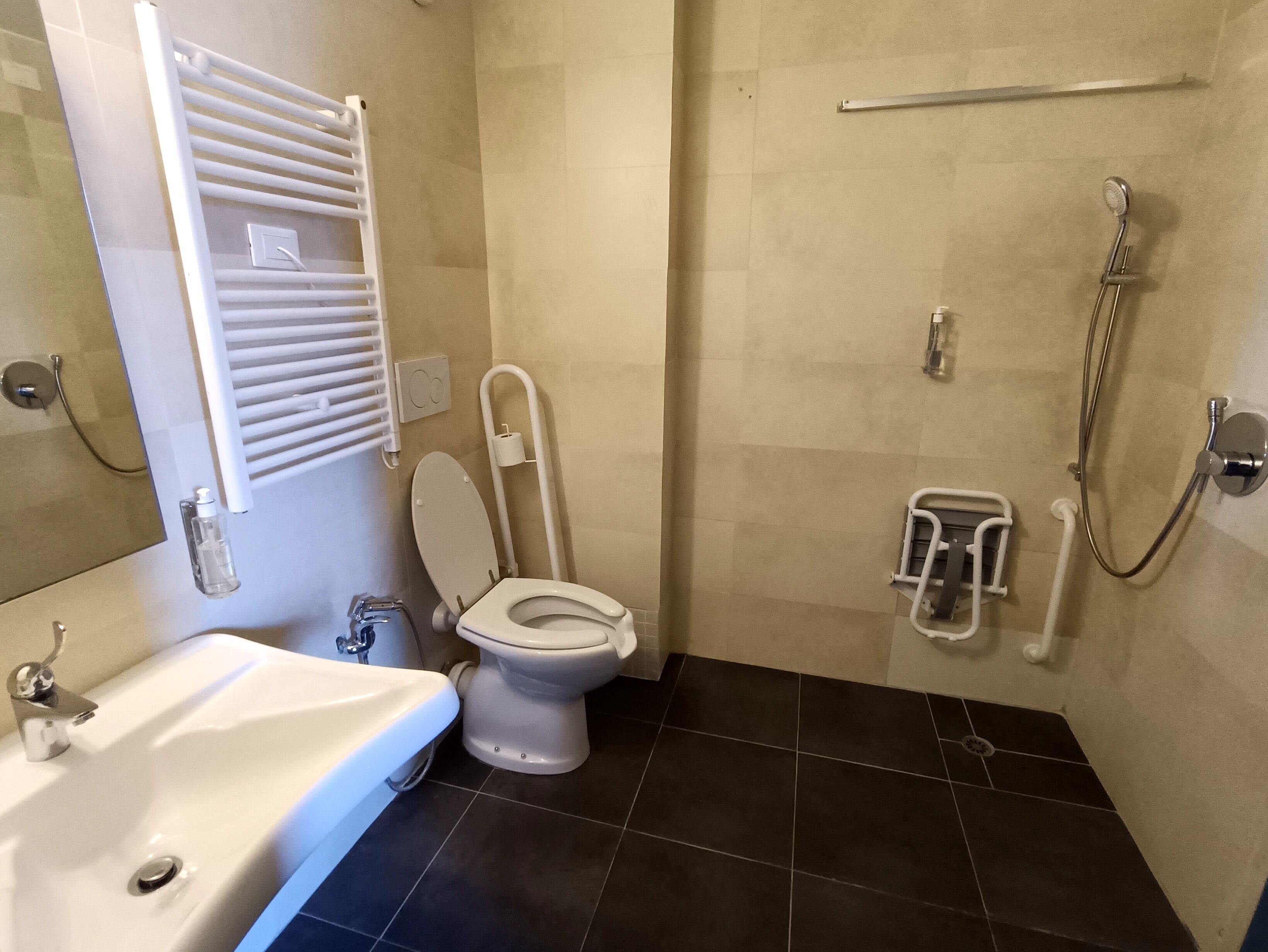 A bathroom with a white sink, toilet, and shower.