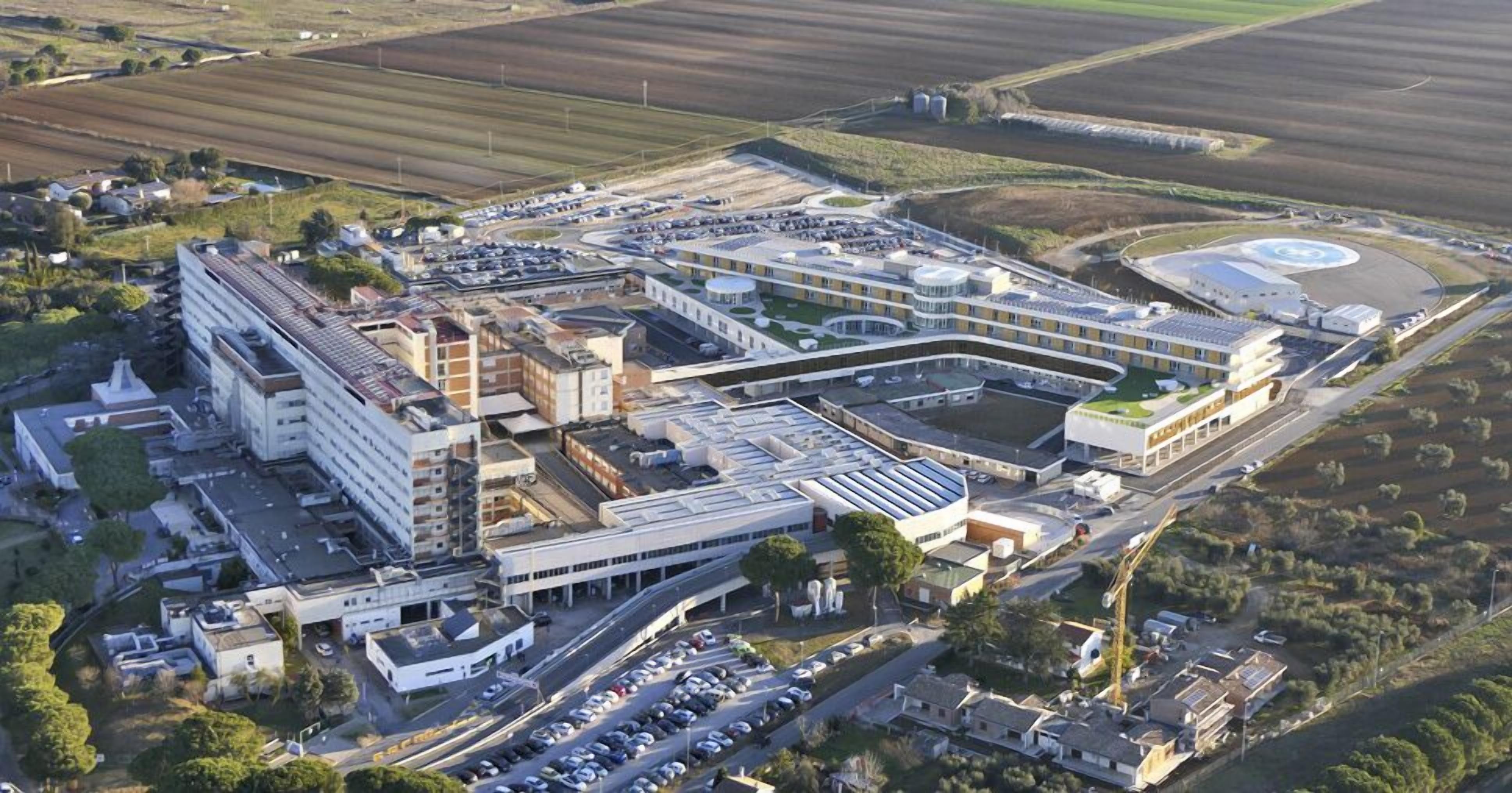 Una terminal aeroportuaria con varios edificios, zonas de estacionamiento y una pista de aterrizaje.