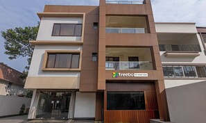 A modern multi-story hotel with a prominent logo and name on the facade. - Treebo The Golden Sands, Bistupur (Jamshedpur)